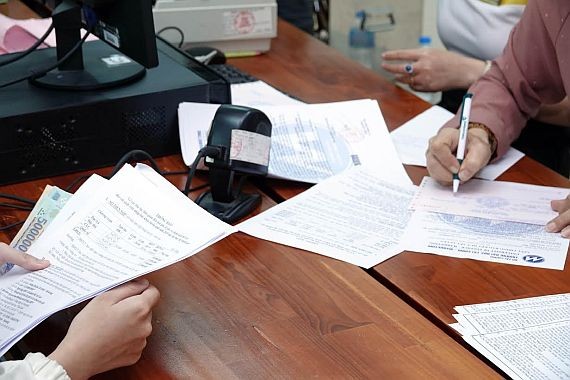 本市某所大學的學生正在辦理貸款手續。