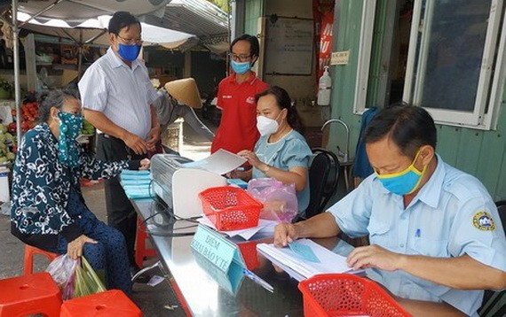 傳統街市人員檢查消費者的購物券。