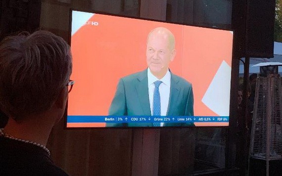 26日晚，在德國萊法州駐柏林代表處內舉辦的選舉之夜活動上，人們在電視前觀看社民黨總理候選人肖爾茨發表演講。（圖源：互聯網）