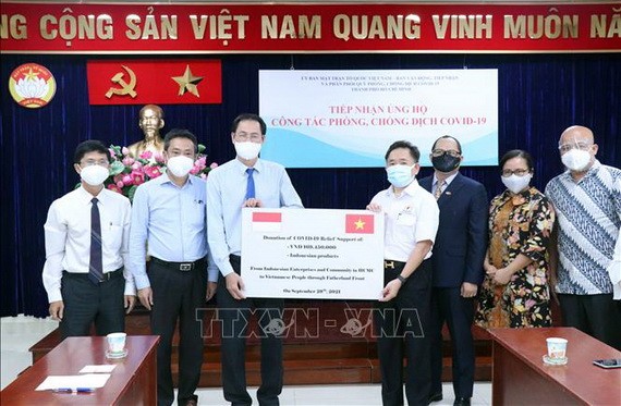 本市印尼商會和印尼人共同體代表象徵性向市越南祖國陣線委員會轉交捐贈的款項和必需品。(圖源:越通社)