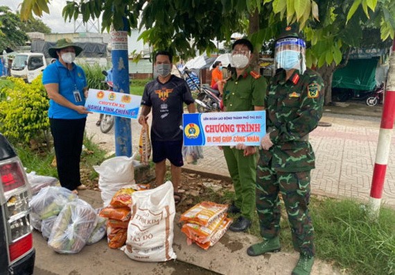 守德市勞動聯團副主席阮氏玉香（左一）向隔離區工人贈送禮物。
