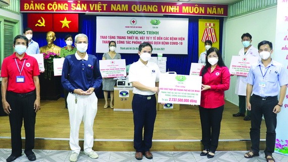 慈濟慈善會越南人醫會黃清俊醫生（中）向鄧氏明孝副主席轉贈醫療裝設備及醫用品。