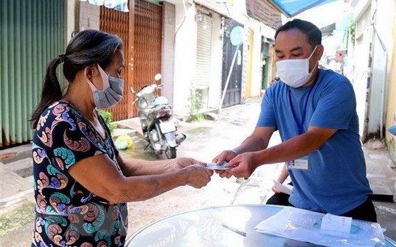 一名受疫情影響的當地居民正領取輔助金。（圖源：互聯網）