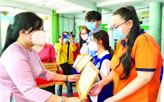 郡婦女會主席陳氏雪幸(左)向貧困優秀生頒發阮氏明開助學金。