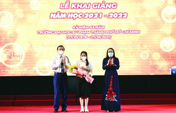 市委宣教處副主任黎鴻山(左)，市師大黨委書記兼董事會主席阮氏明紅(右)向優秀生頒獎。