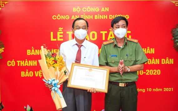 阮全勝主任向陳永安頒發公安部的獎狀。