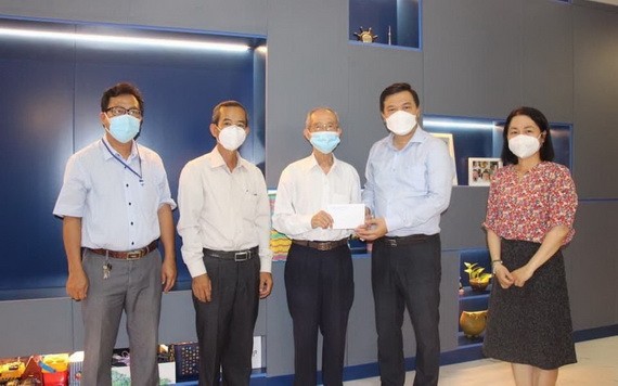 守德市委民運處副主任李黃南（右二）向華人老革命陳健智（右三）贈送禮物。