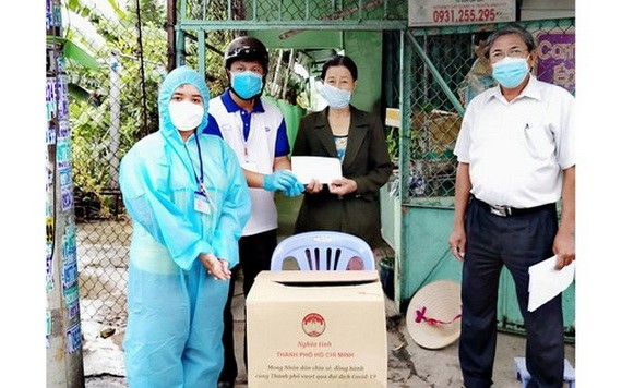 在疫情複雜多變的背景下，許多黨員在黨和人民前體現了其先鋒責任。圖中：陳文欣黨員（右）向守德市鈴中坊貧困居民贈送禮物。