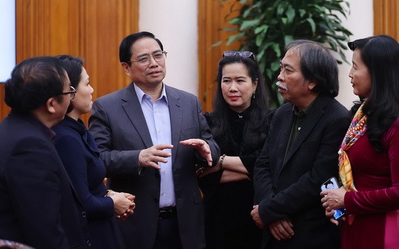 政府總理范明政(左三)同與會代表交談。(圖:越通社)
