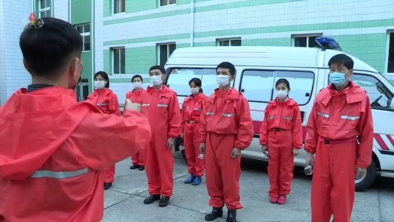 防疫工作人員在聽取領導幹部的說明。（圖：韓聯社） 