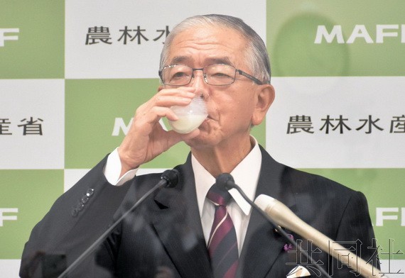 12月17日,日本農相金子原二郎在記者會上喝酸奶飲品。(圖:共同社)