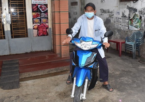 武文新（家住富潤郡）騎著獲贈送作為謀生工具的摩托車。