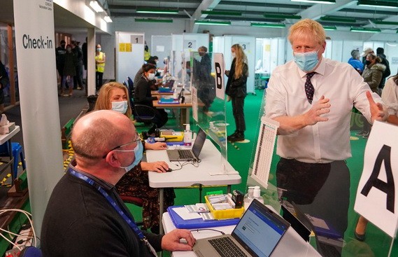 英首相約翰遜(右)前往新冠疫苗接種中心視察。（圖：路透社）