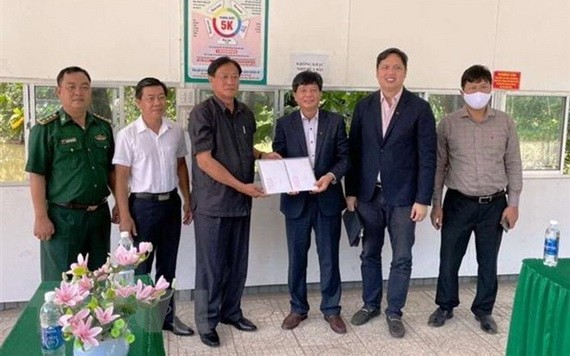 堅江省外務廳長文公鬥（左三）通過越南駐柬埔寨西哈努克省領事館代表向居柬越僑貧困同胞贈送3億元。（圖：越通社）