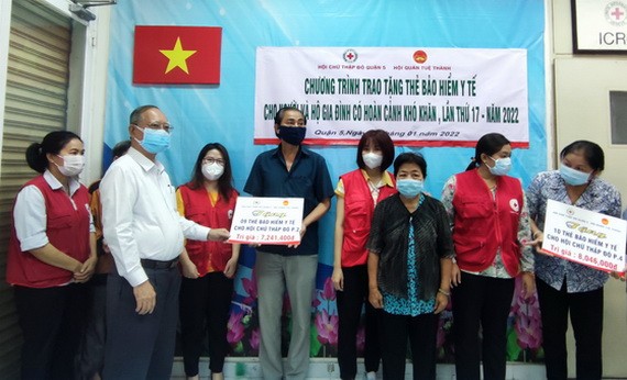 穗城會館理事長盧耀南向第二坊貧困戶代表贈送醫保卡。