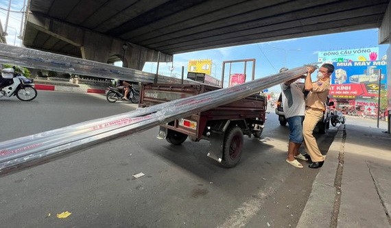 交警力量在守德市13號國道對載運超大物料的場合進行處罰。