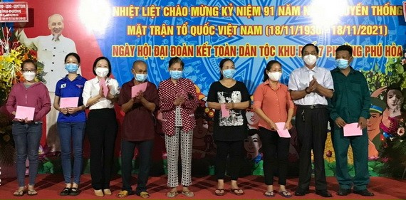 天后宮副理事長陳永安（右二）在全民族大團結日向富和坊民眾贈送禮物。