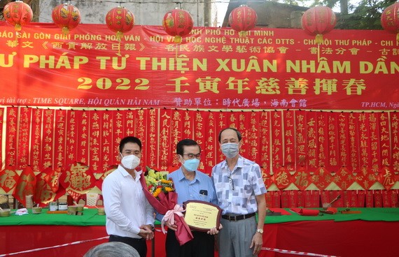 本報編委文忠孝（左）向海南會館理事長吳清華先生贈送紀念章，感謝會館5年來為慈善揮春活動熱情提供場地。