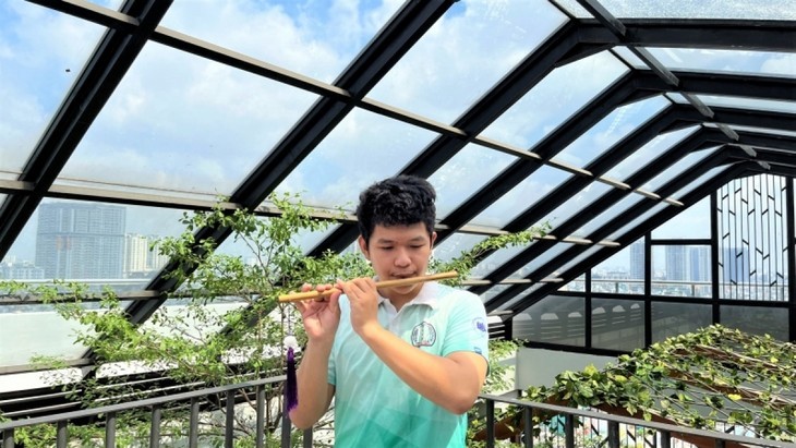 胡志明市經濟大學民歌俱樂部樂器隊隊長范文明吹竹笛。