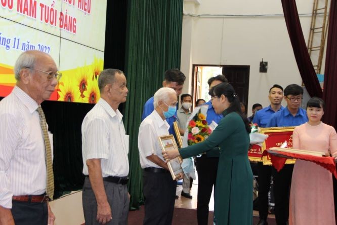 新富郡委書記黎氏金紅向三位老黨員頒授60年黨齡紀念章。（圖：陳燕）