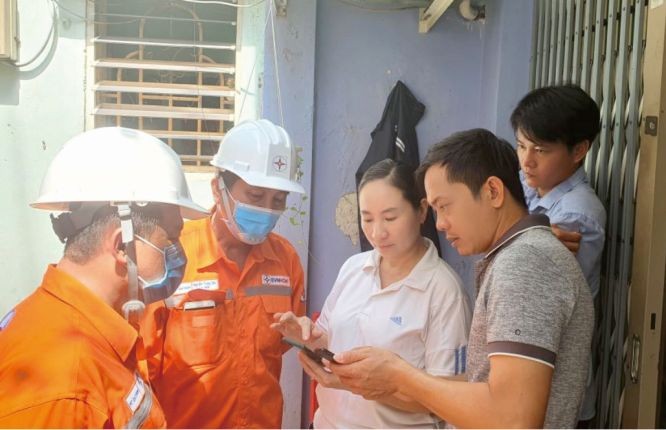 電力公司人員指引民眾使用電力公司應用查詢資訊。