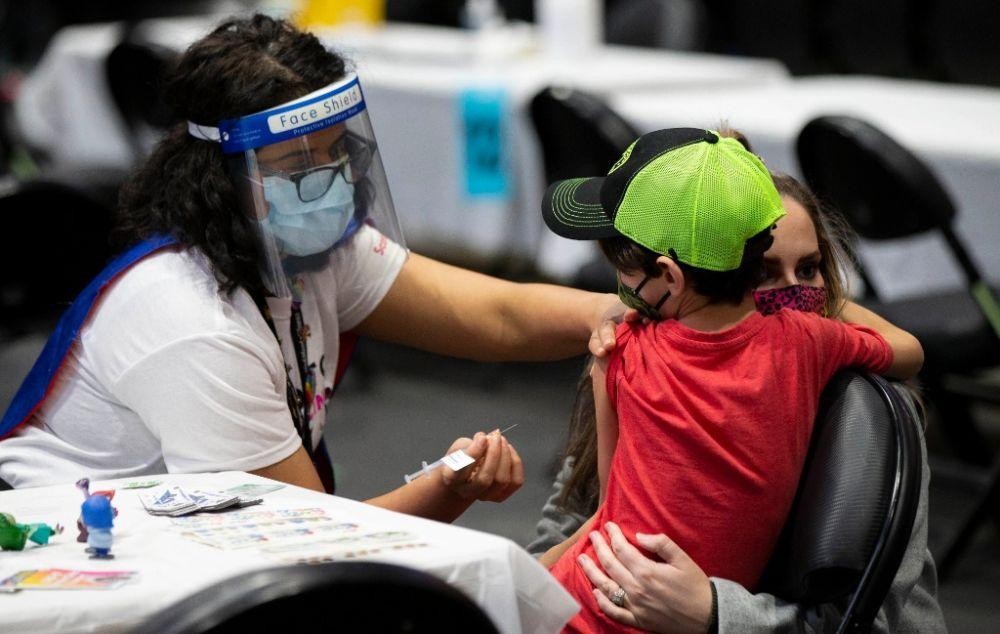 圖為 2021年12月12日，在加拿大多倫多的一處新冠疫苗接種中心，接種員準備為一名兒童接種疫苗。（圖：新華社）