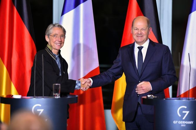 德國總理朔爾茨（右）同法國總理博爾內在新聞發佈會上握手。（圖：新華社）