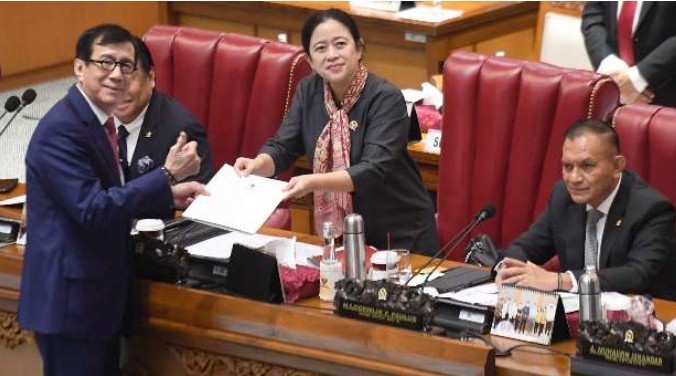 12月15日,在雅加達國會大廈召開的全體會議上,司法人全部長雅索納(左)將關於《印尼和新加坡政府引渡協議法案》總統的最終意見檔案遞交給國會議長普安(右二)。(圖:印尼商報)