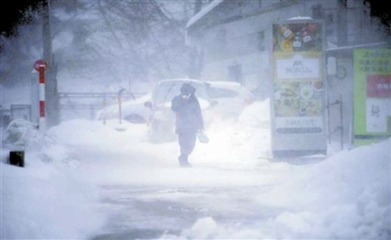 12月23日，行人在日本山形縣山形市藏王溫泉冒雪前行。（圖：新華社）