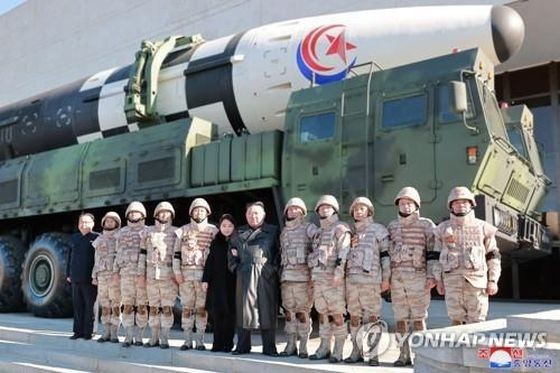 朝鮮國務委員會委員長金正恩(右六)日前攜女兒(右七)同成功試射“火星-17”型洲際導彈有功人員合影。(圖:韓聯社/朝中社)