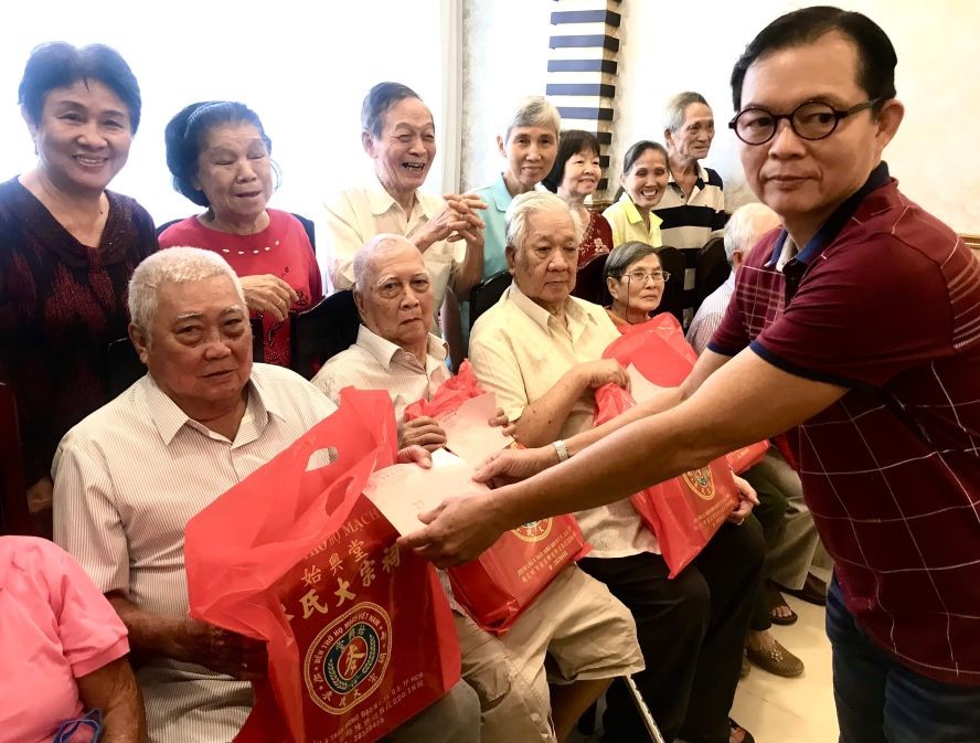 理事长麦少权向老宗亲发送礼物。