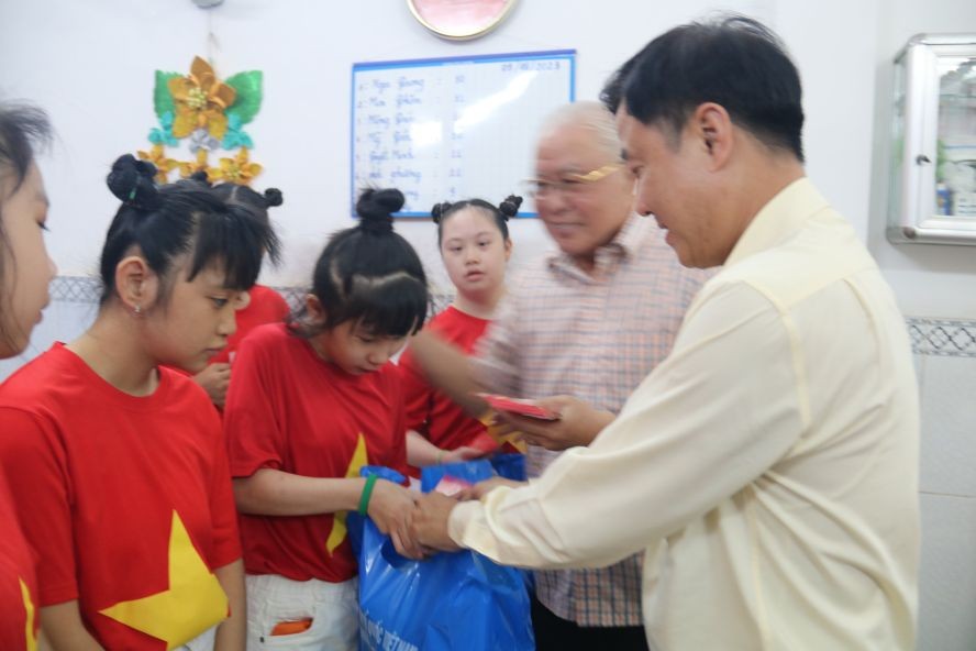 第五郡越南祖国阵线委员会主席黎晋才以及华人热心人士吕永雄向学生赠送新年礼物。