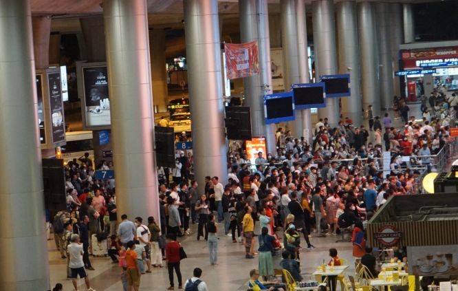 图为1月6日晚,数百人在新山一机场国际航站楼大厅外等候迎接从外国回来的亲人。(图:VNN)