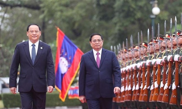 政府总理范明政(右)与老挝政府总理宋赛·西潘敦检阅仪仗队。(图:越通社)