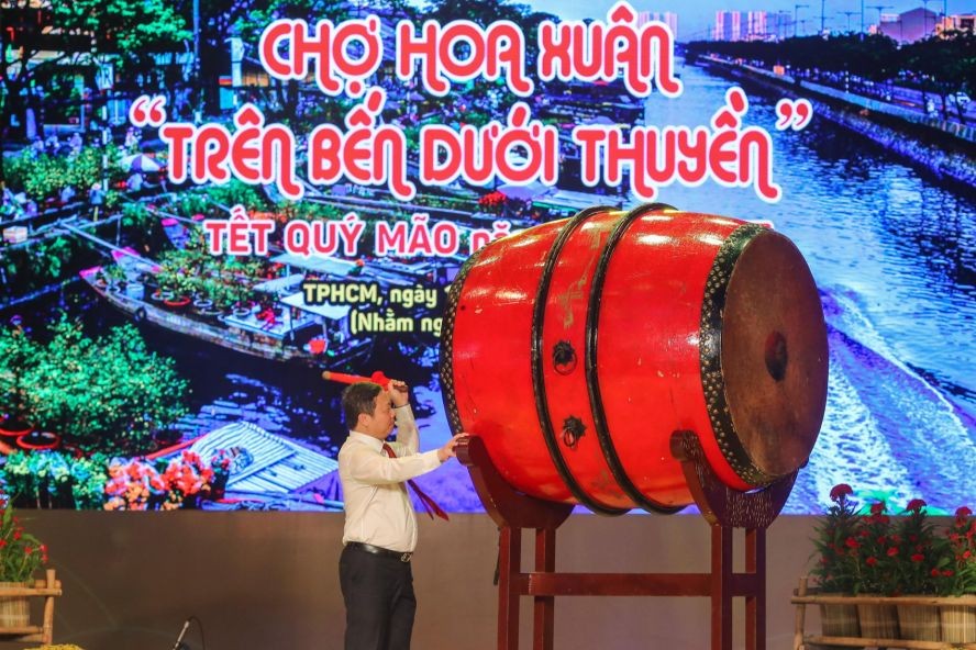 市人委会副主席杨英德为春花会击鼓开幕。