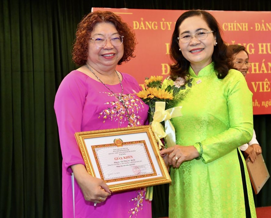 市人民议会主席阮氏丽与模范党员、市各民族文学艺术协会副主席张四妹合照。