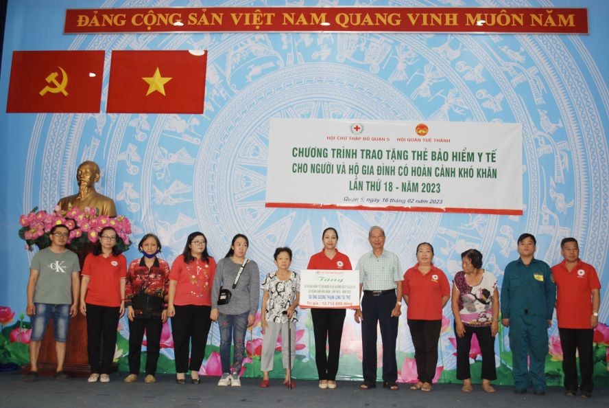 华人热心人士杨顺龙先生（右五）向贫困者赠送医保卡。