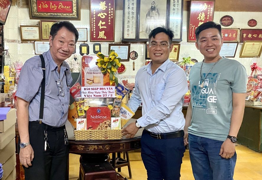 本报编委文忠孝（右二）向周华邦住持赠送礼物祝贺。