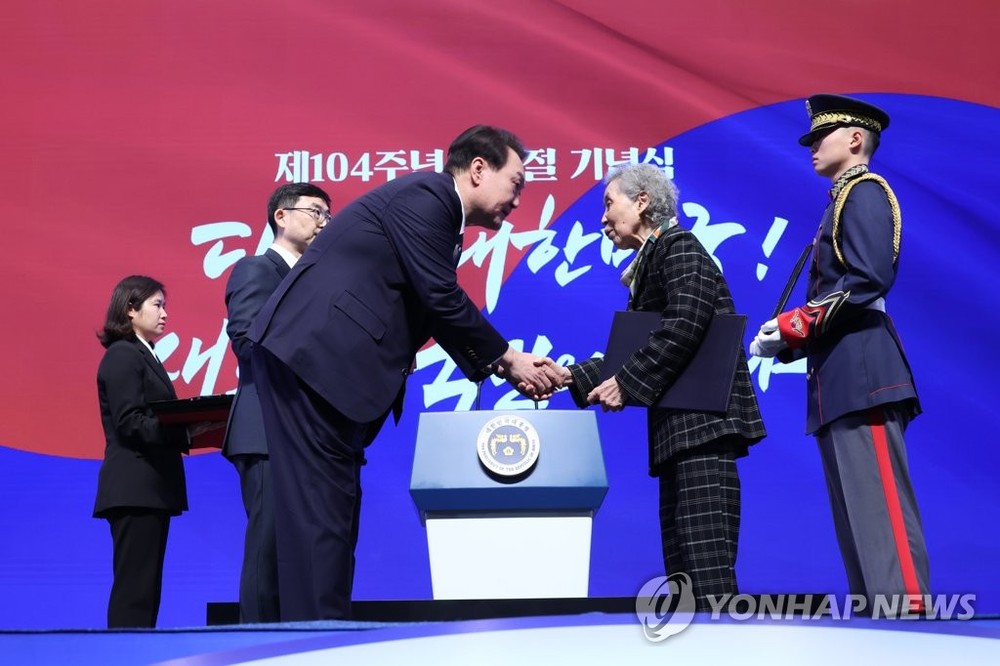 3月1日，三一独立运动104周年纪念仪式在首尔市中区的柳宽顺纪念馆举行。韩国总统尹锡悦（左）向独立运动家金彦培遗属授予“建国勋章爱国章”。（图：韩联社）