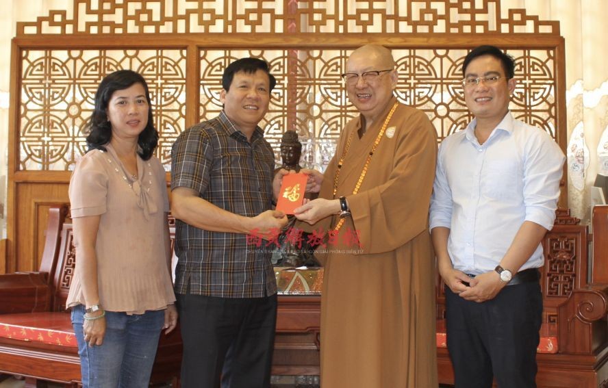 草堂禅寺住持释了明法师(右二)把赞助赠报经费交给本报领导。