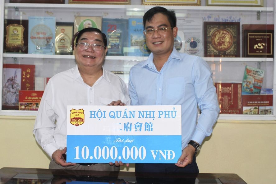 二府会馆理事长彭伟强将赞助赠报经费的1000万元交给本报编委文忠孝。