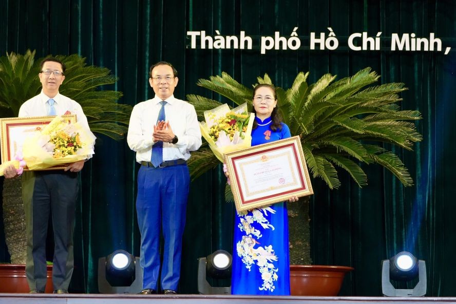 市委书记阮文年（中）向市人民议会主席阮氏丽、市委宣教处副主任范德海颁授三等劳动勋章。（图：黄雄）