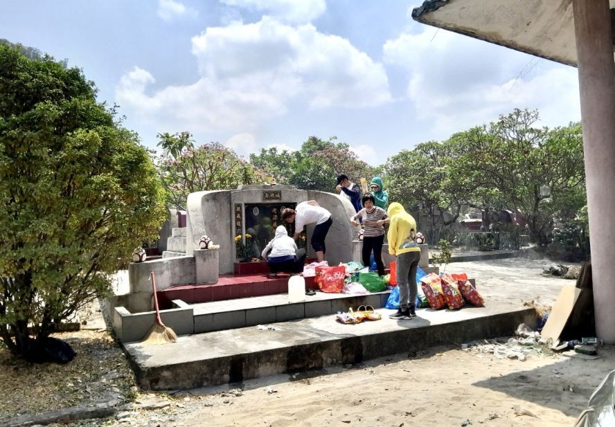 人们顶着烈阳在扫墓。