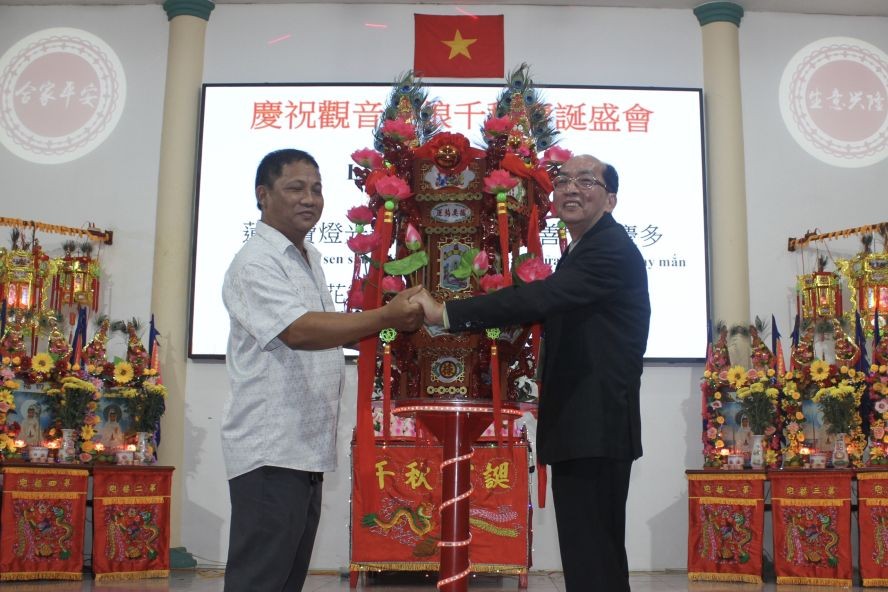 该庙理事长黄伟峰（右）向刘权先生移交“观音莲花宝灯”。