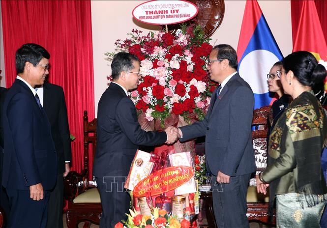 岘港市市委书记阮文广(中左)与老挝总领事苏潘·哈道黄握手致意。(图:越通社)