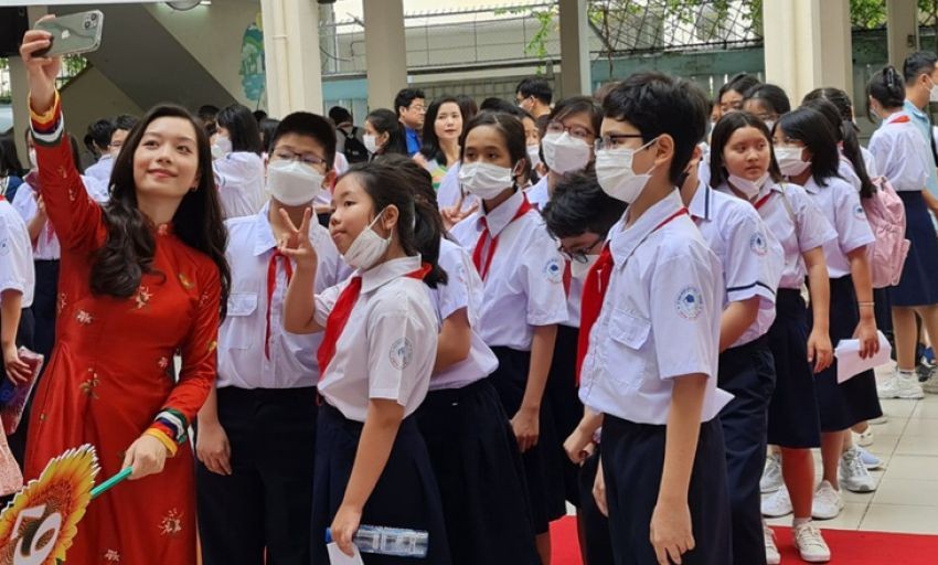 女老师在校园里同学生们自拍留念。（示意图：黄香）