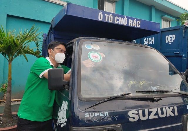 胡志明市都市环境一成员有限责任公司员工在楚鸡垃圾中转站给一辆垃圾收集车张贴管理标志。(图:潘秋怀)