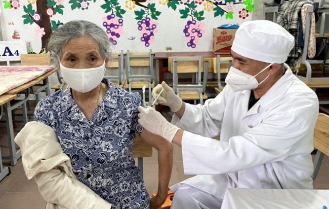 医护人员在给一位老大娘施打新冠疫苗加强针。(图:安然)