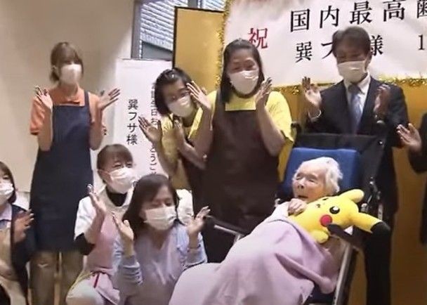 众人围绕在巽房身边献上祝贺。(图:互联网)