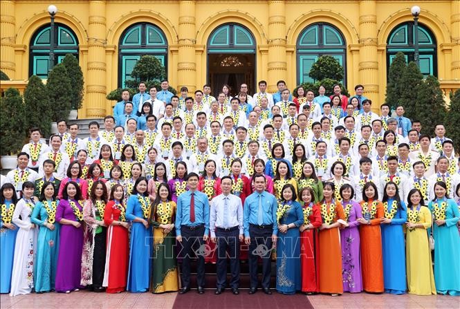 国家主席武文赏(前中)在主席府前同133集体、个人模范合影留念。(图:越通社)